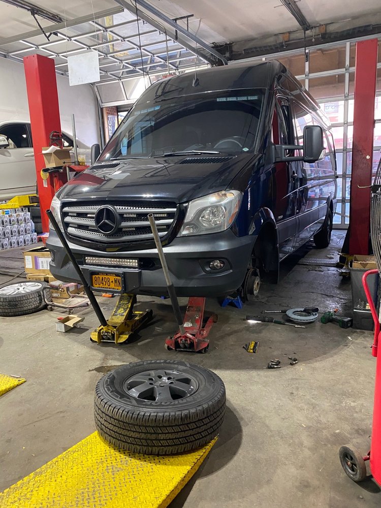 A Mercedes on a lift being worked on