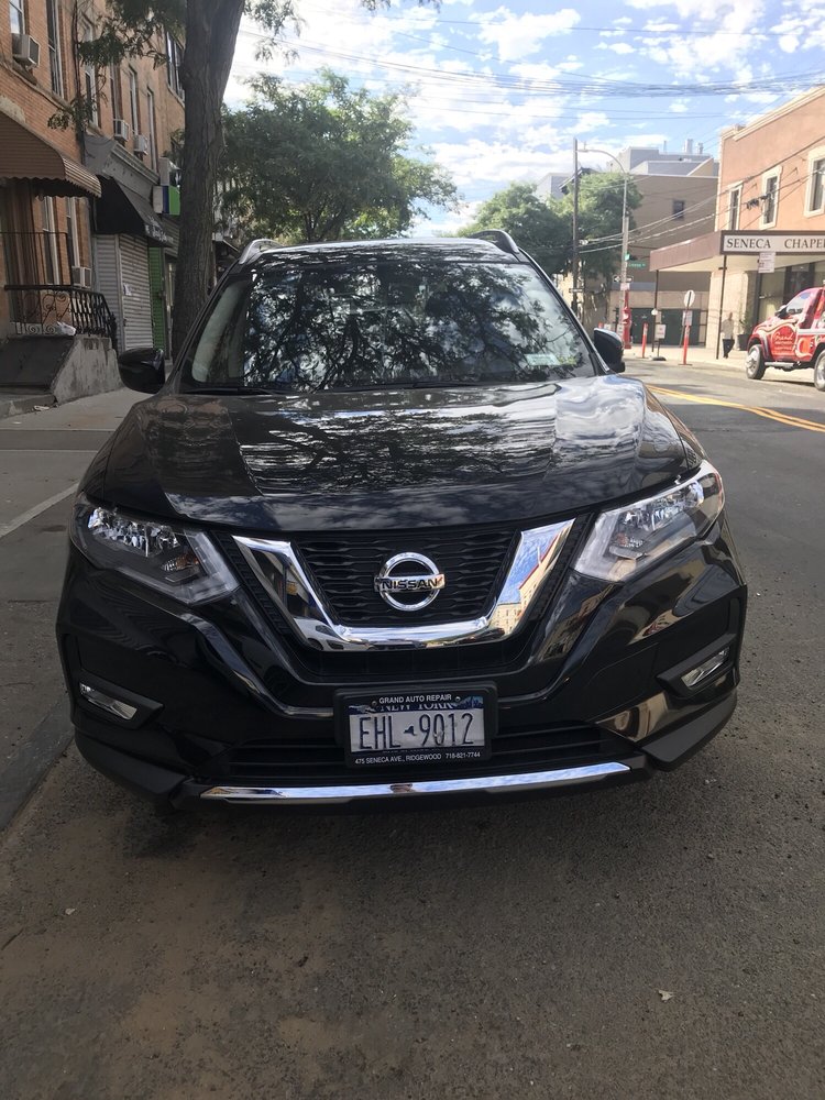 The front of a black Nissan which has been repaired