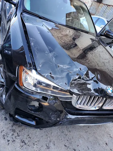 A black BMW which has been in a collision